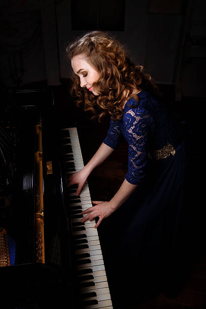 istock Young woman playing the grand piano 542186940