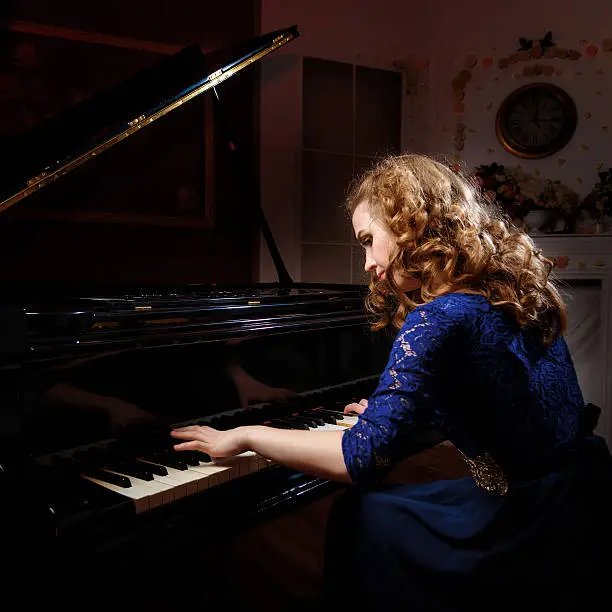 Photo of Young woman playing the grand piano