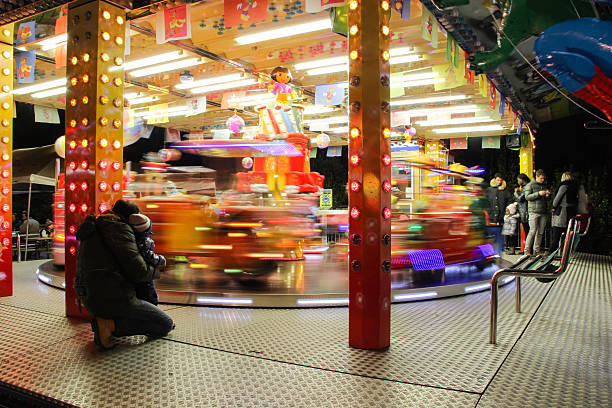 carrousel dans la nuit en famille au luna park. - blurred motion amusement park spinning lighting equipment photos et images de collection
