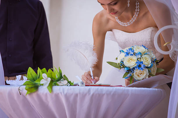 istock bride signing wedding certificate in park 542189420