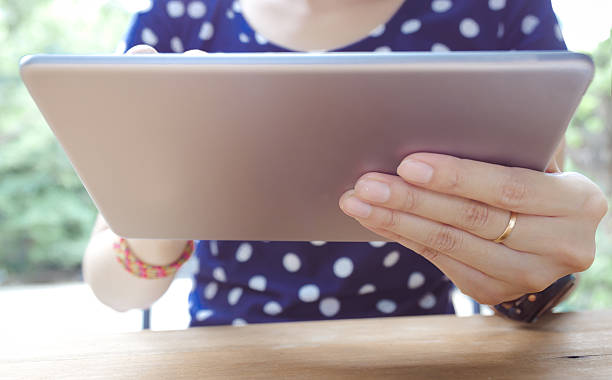 istock Asian woman using tablet pc on a wood table 542191088