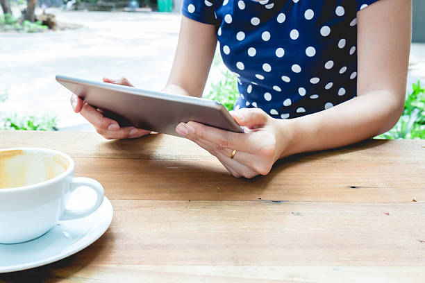 istock Asian woman using tablet pc on a wood table 542191184