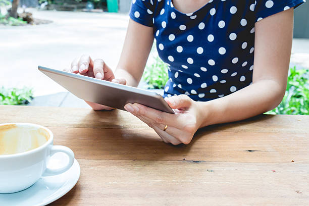 istock Asian woman using tablet pc on a wood table 542191290