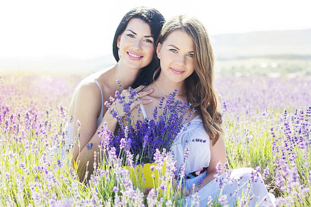 Two sisters are resting on the purple field of lavender stock photo