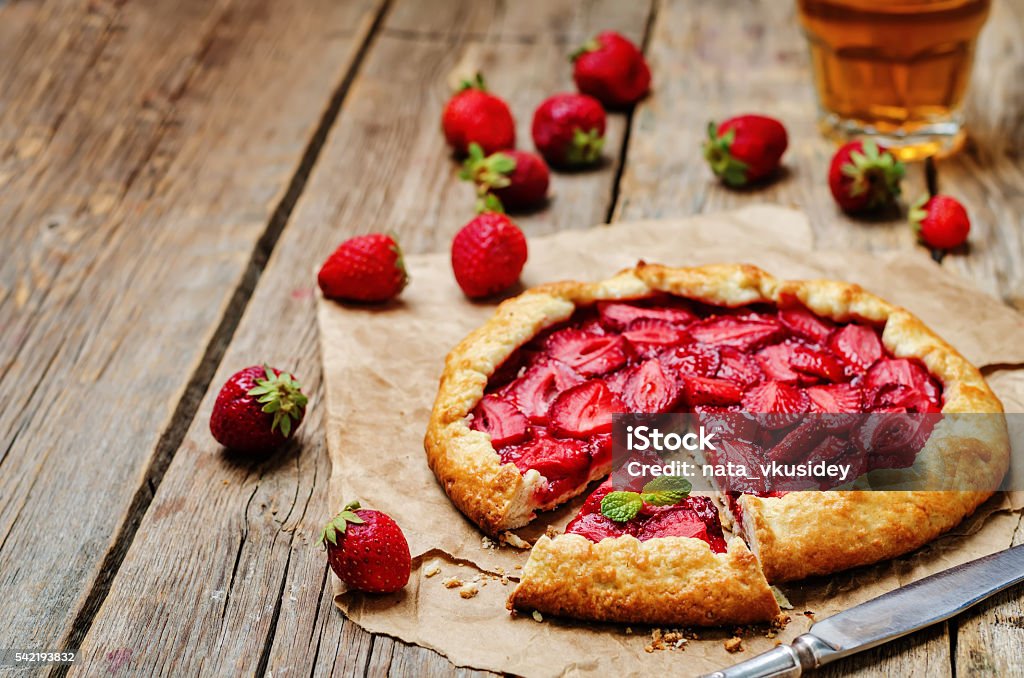 Strawberry cake Strawberry galette on a a dark wood background. toning. selective focus Crostata Stock Photo