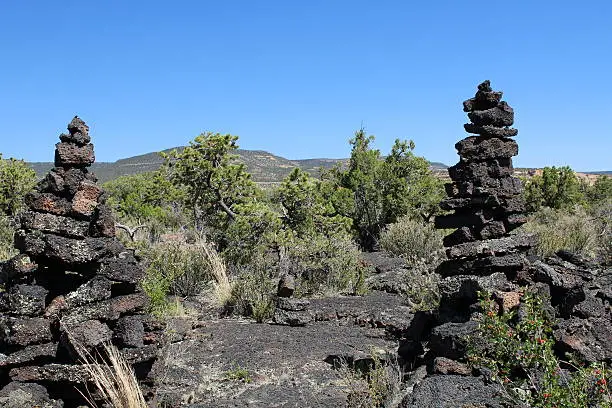 Pair of rock cairns marking the way along the Zuni-Acoma trail through the El Malpais lava flow near Grants, New Mexico.