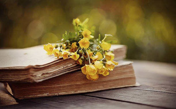 istock Bouquet of buttercups on old books on a table. 542195492