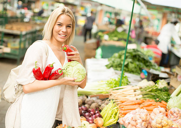 Young woman buying vegetables at the market