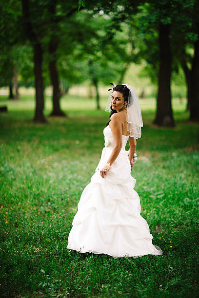 istock beautiful young bride stand on background forest 542196112
