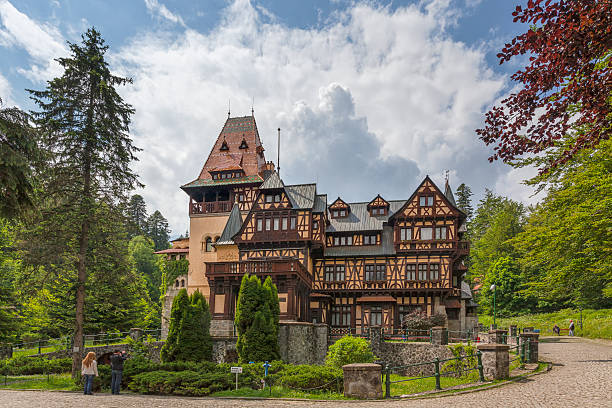 Sinaia, Romania - June 4, 2016: A couple stops to take a picture of Pelisor Castle, a royal castle built between 1899 and 1903 for King Carol I of Romania. It is now a museum and open to the public.