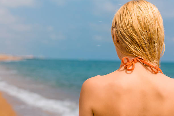 Beautiful young multicultural woman reading a book while lounging in the French Riviera.