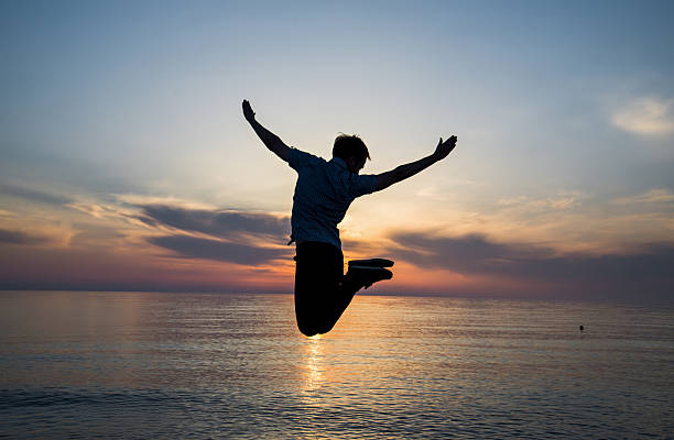 istock Silhouette man is jumping at the beach on twilight sea 542201578