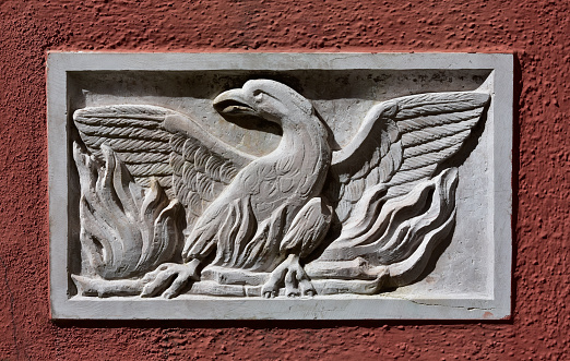 Old Patera (Venice public art) with phoenix theatre symbol on a wall near the famous opera house