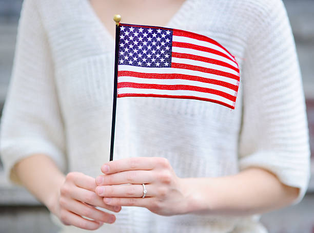 istock Young woman holding american flag 542202388