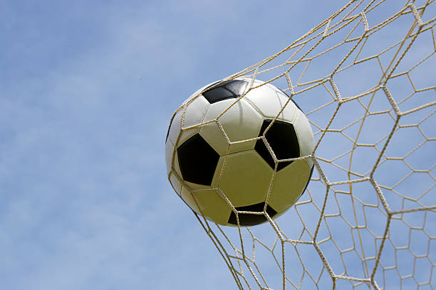 istock foot ball in the goal net 542202482
