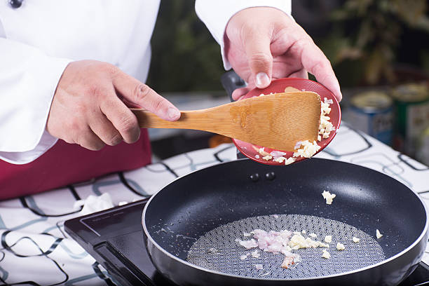 istock Chef putting garlic and red onuion to the pan 542202978