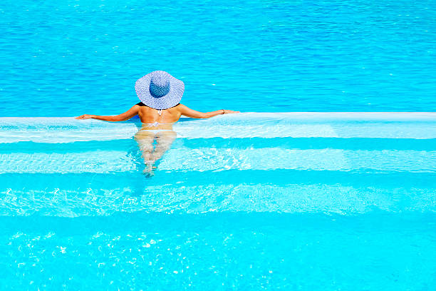 istock woman relaxing at a resort swimming pool 542205192