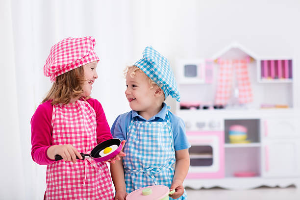 Happy kids playing with toy kitchen