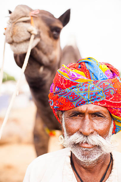 istock Senior Indian Man with Camel at Pushkar Camel Fair 542207418
