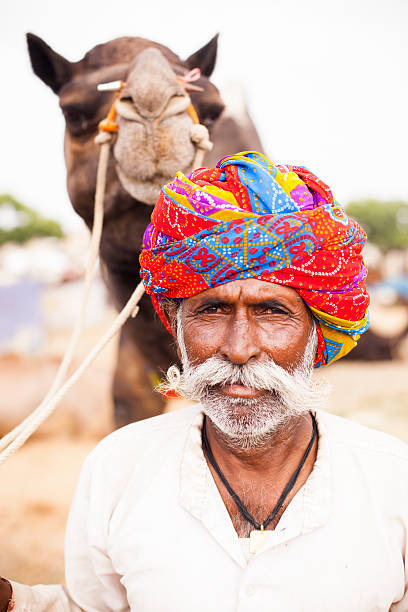 istock Senior Indian Man with Camel at Pushkar Camel Fair 542207424