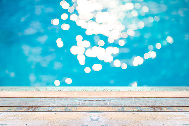 istock Wood table top and blurry blue water bokeh abstract background 542207866