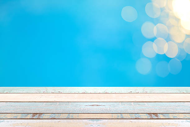 istock Wood table top and blurry blue water bokeh abstract background 542208210