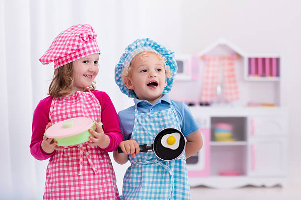 istock Adorable kids playing with toy kitchen 542210028