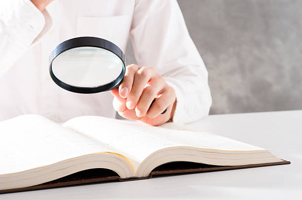 istock Men read a book with a magnifying glass 542210220