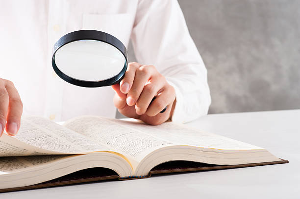 istock Men read a book with a magnifying glass 542210230