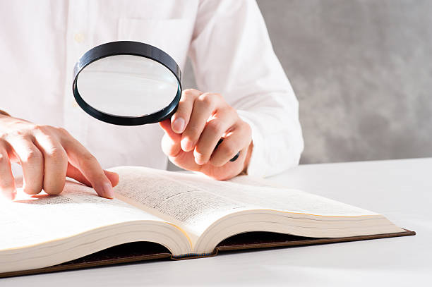 istock Men read a book with a magnifying glass 542210236