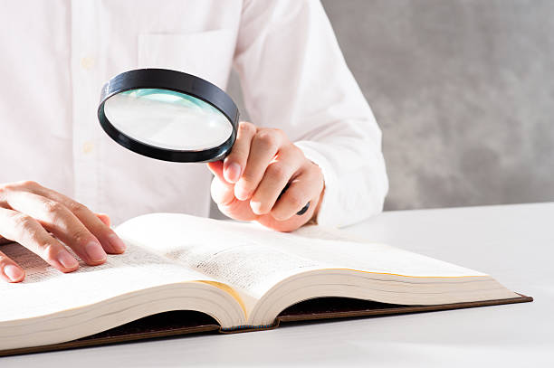 istock Men read a book with a magnifying glass 542210250
