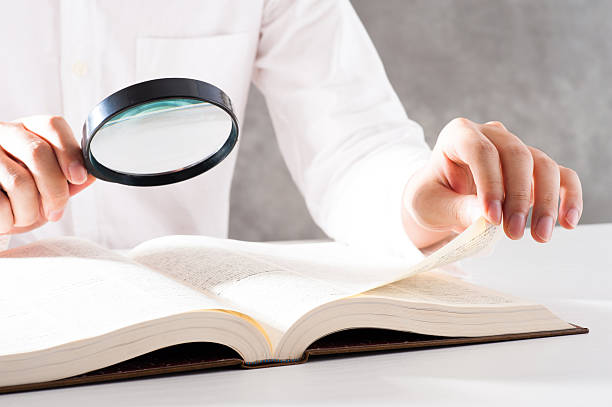 istock Men read a book with a magnifying glass 542210262