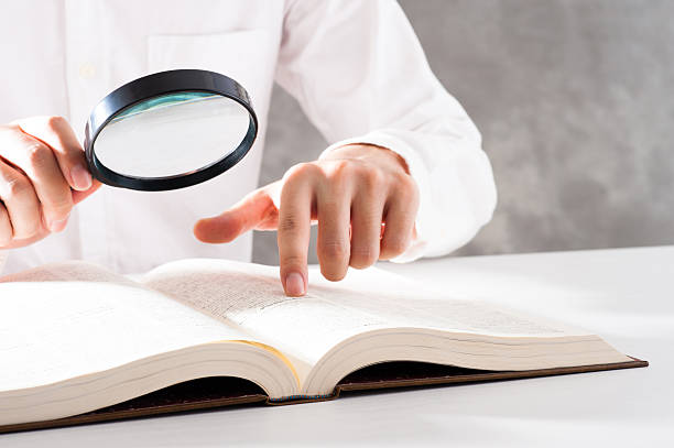 istock Men read a book with a magnifying glass 542210270