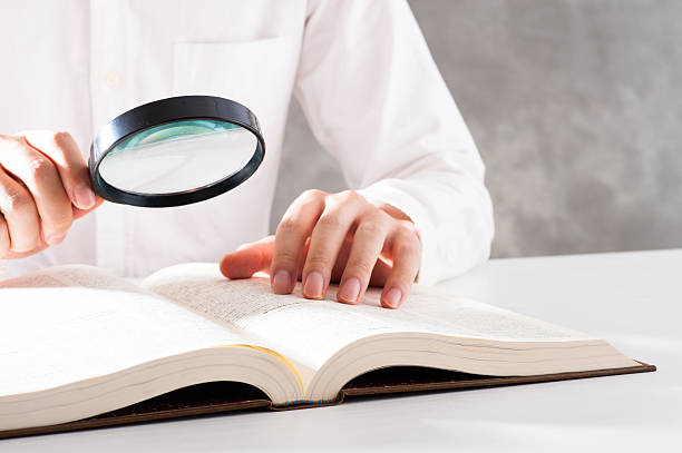 istock Men read a book with a magnifying glass 542210280