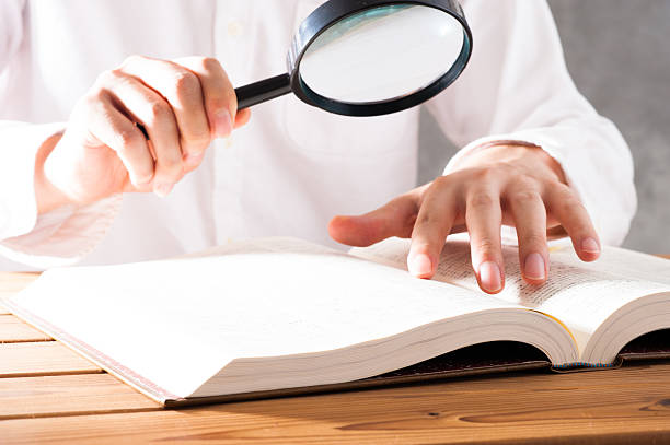 istock Men read a book with a magnifying glass 542210322