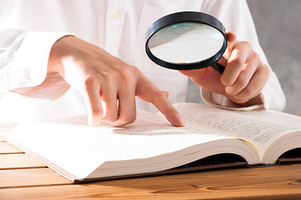 istock Men read a book with a magnifying glass 542210334
