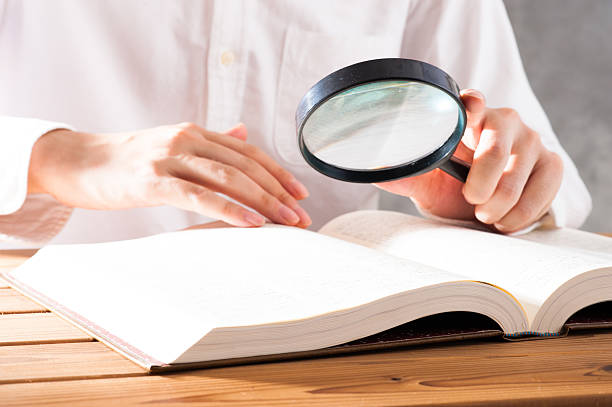 istock Men read a book with a magnifying glass 542210352