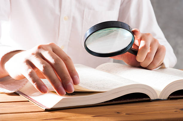 istock Men read a book with a magnifying glass 542210370