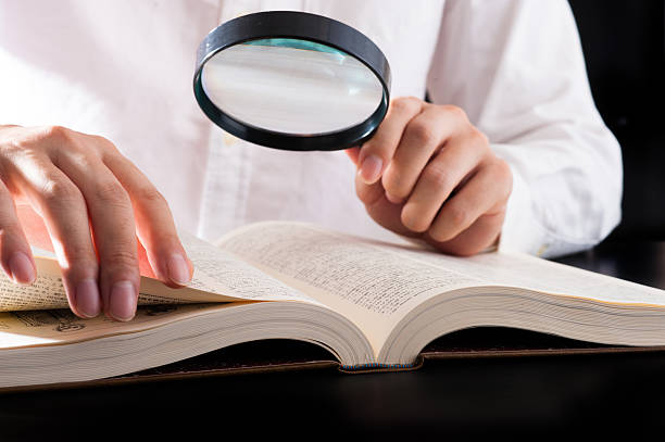 istock Men read a book with a magnifying glass 542210406