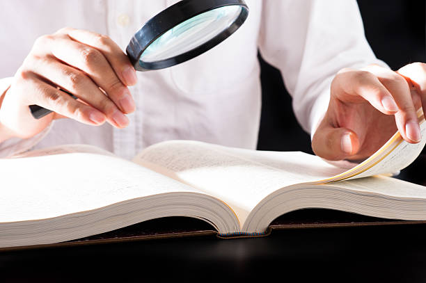 istock Men read a book with a magnifying glass 542210422