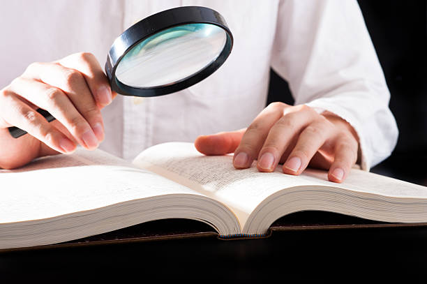 istock Men read a book with a magnifying glass 542210426