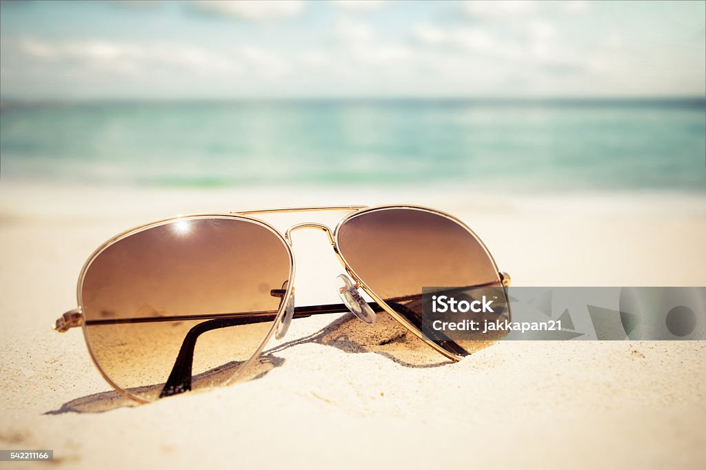 sunglasses Sunglasses on sandy beach in summer - vintage color styles Sunglasses Stock Photo