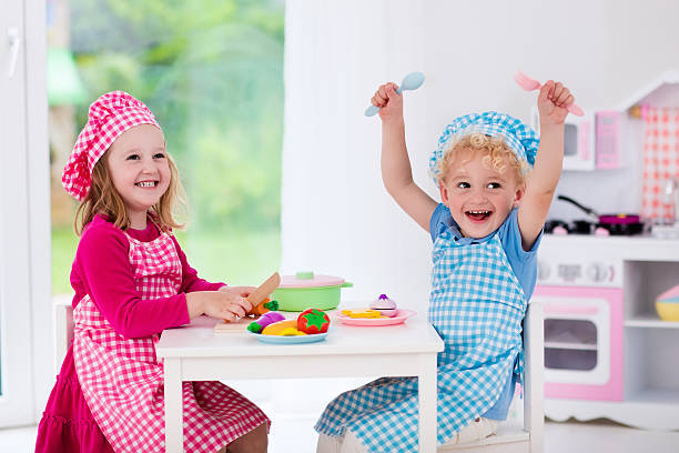 istock Laughing kids playing with toy kitchen 542212344