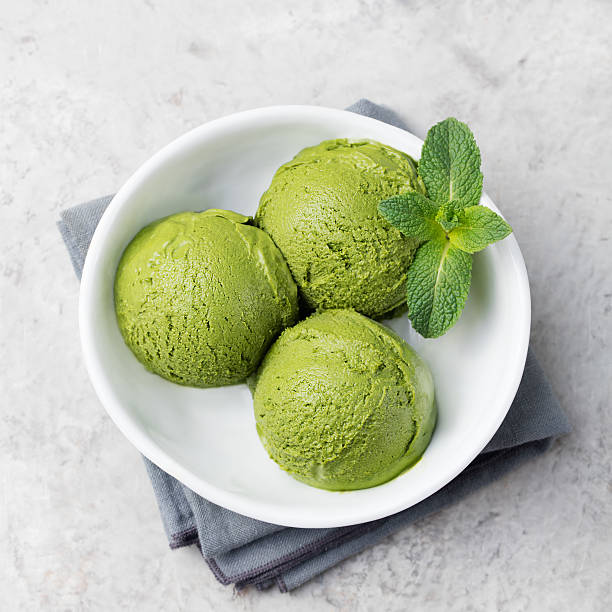 istock Green tea matcha ice cream in white bowl Top view. 542213766