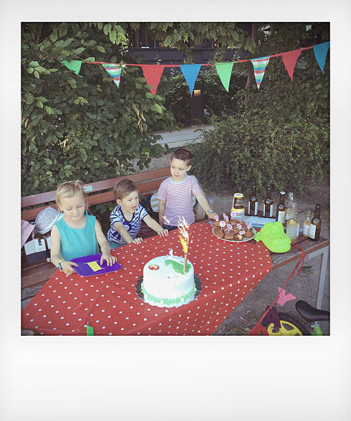 Blowing candles on a birthday cake Photo of a children at a birthday party blowing out candles on a birthday cake // polaroid // mobile stock photo  happy birthday cousin images stock pictures, royalty-free photos & images