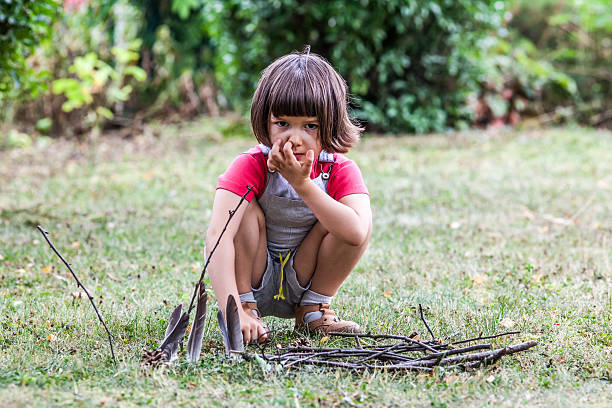 istock thinking little kid playing with wood sticks in green park 542214936