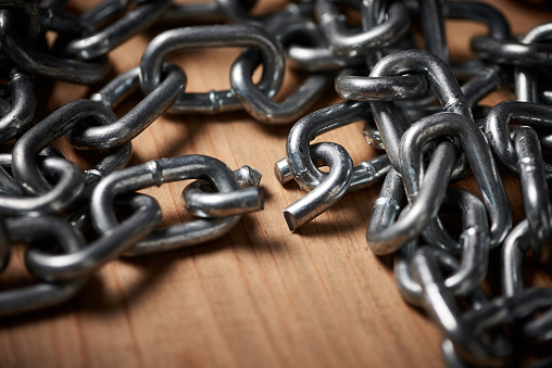 Shot of metal chains with a broken link