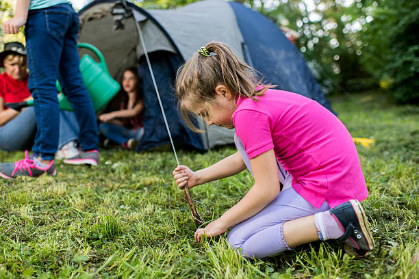 istock Little girl setting the tent on a camping. 542216370