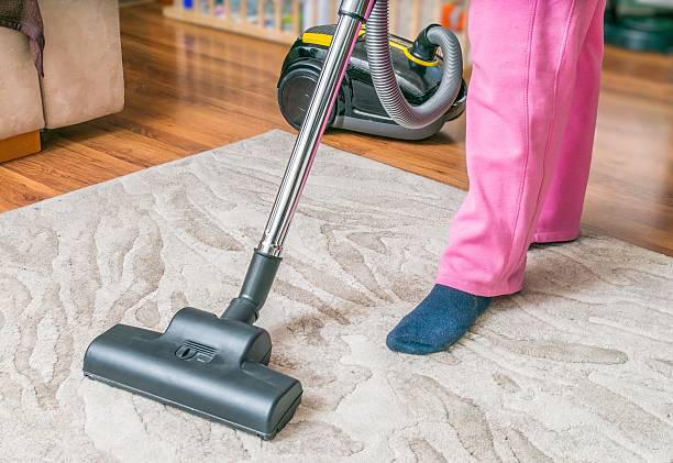 istock Woman is cleaning carpet with vacuum cleaner. 542218372