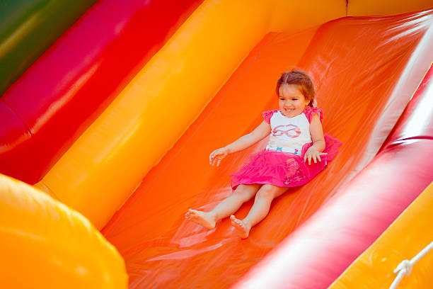 enfant sur un trampoline coloré - inflatable slide sliding child photos et images de collection